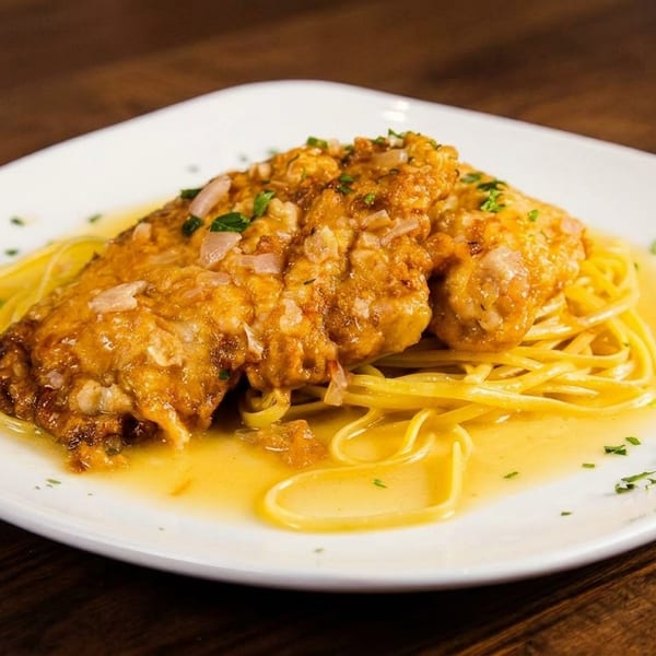Chicken piccata with capers and parsley over linguine pasta in a lemon butter sauce.